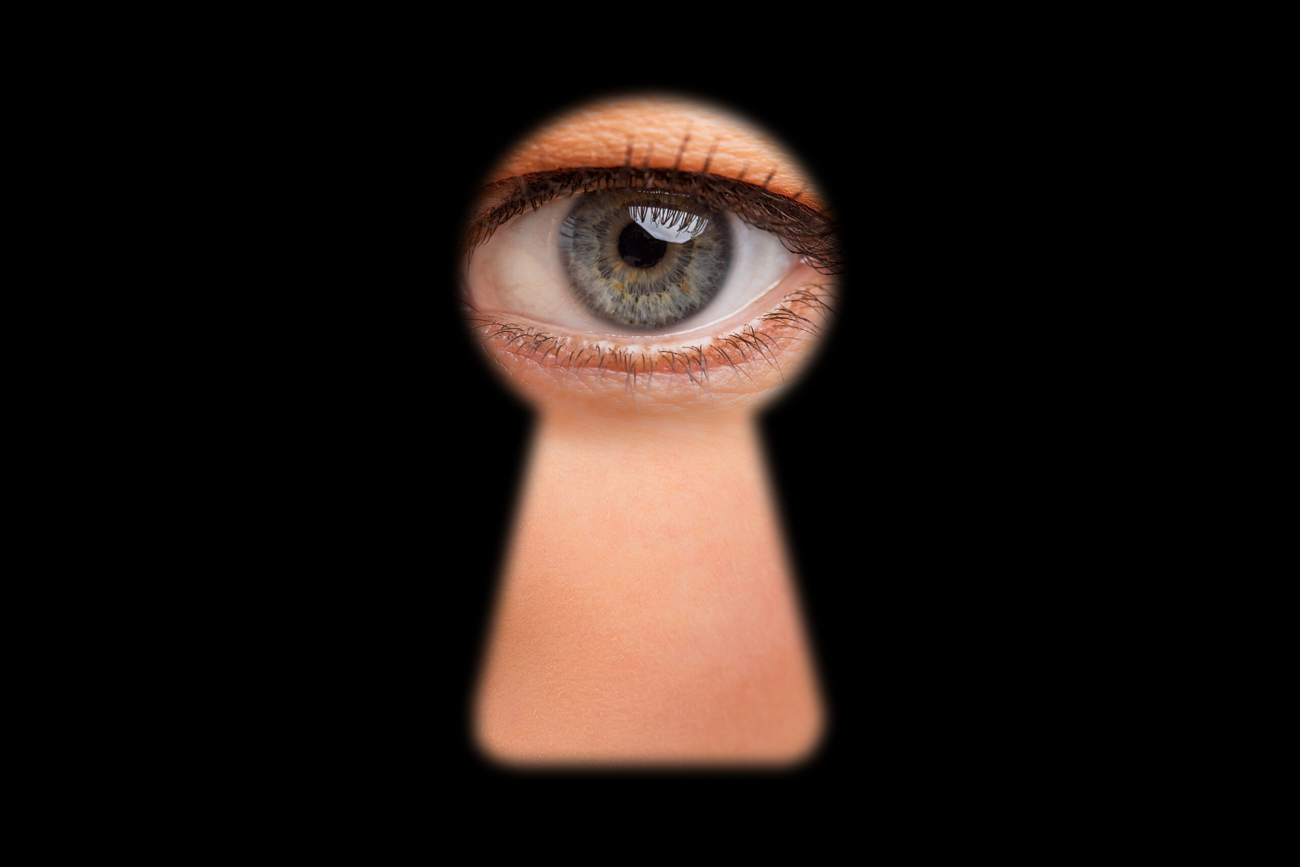 eye-of-person-looking-through-keyhole-in-doors