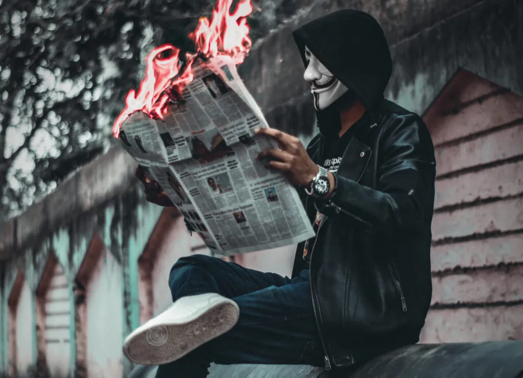 Seated man reading newspaper with flames
